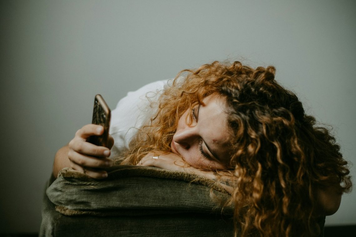 stressed woman scrolling through her phone